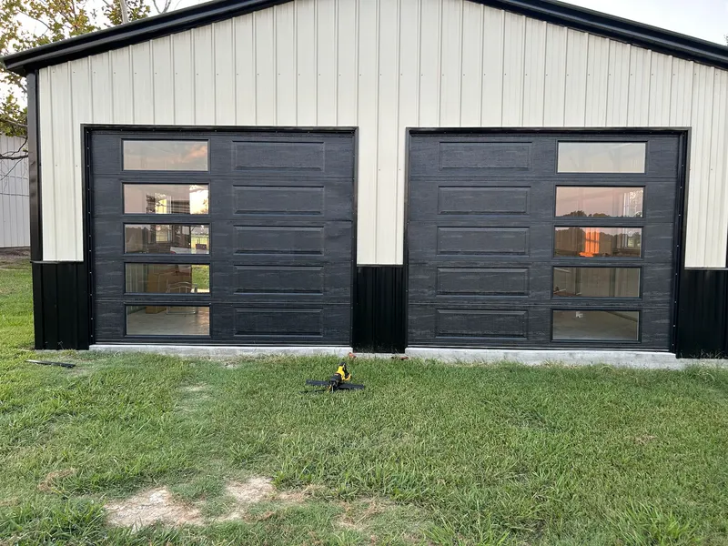 Two black garage doors fitted to a workshop building