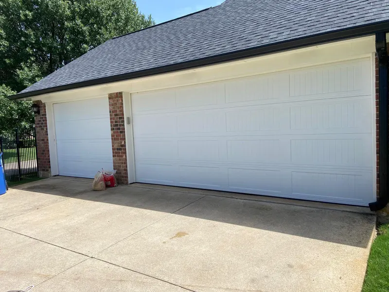 Pair of white garage doors on a red-brick North Texas home